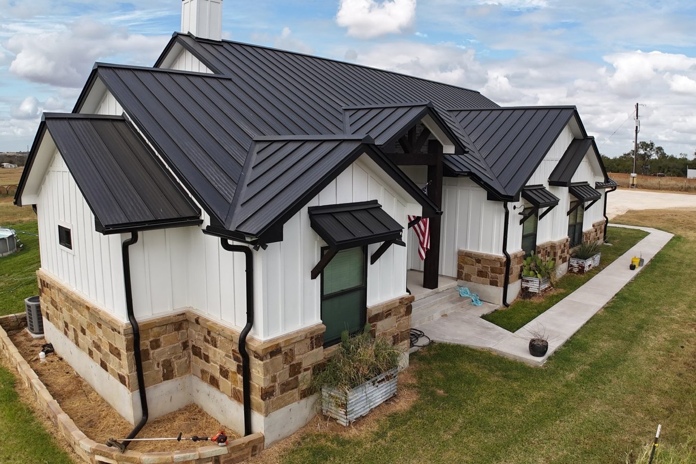 A finished dark standing seam metal roof in low afternoon light